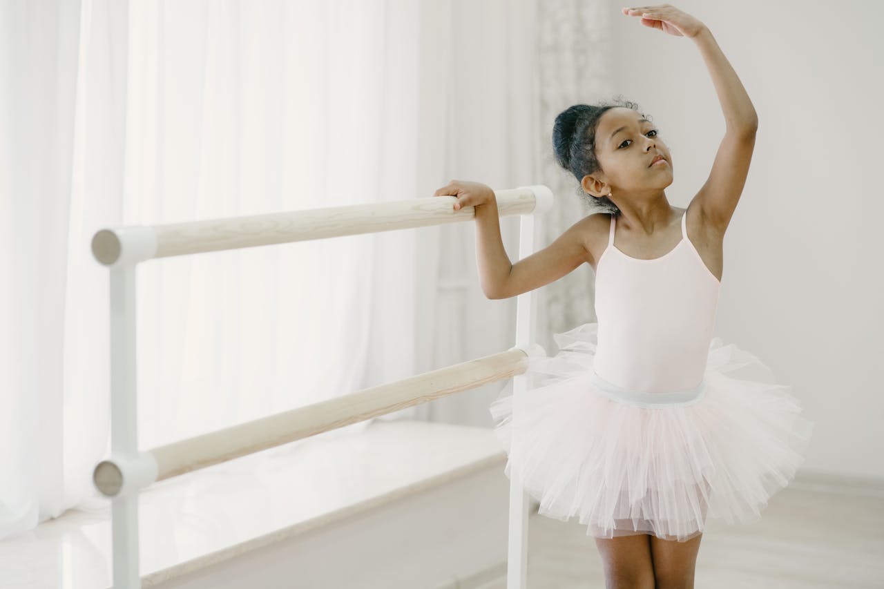 A young ballerina in a tutu practicing ballet at a home studio, showcasing grace and focus.
